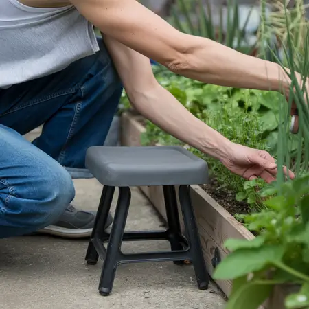 person kneeling down to pick flowers in his garden