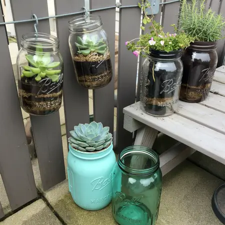 Hanging succulent jars on fence